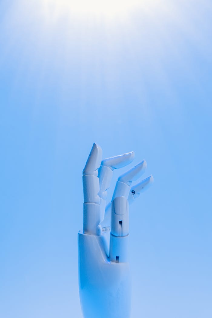 gallery-01 A robotic hand reaching upward against a blue sky, symbolizing technologys future.