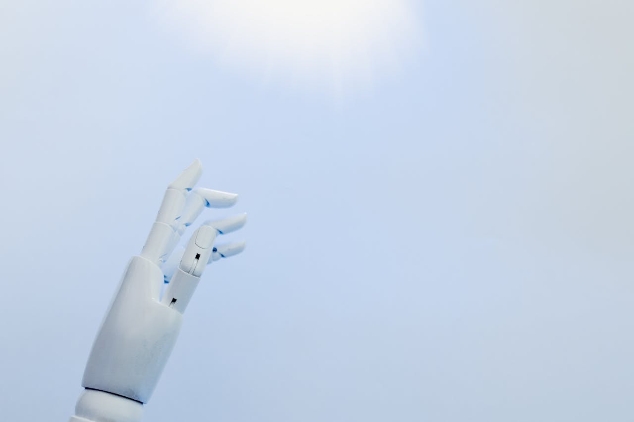 journey-02 A robotic hand reaching towards a bright light on a white background symbolizing innovation.