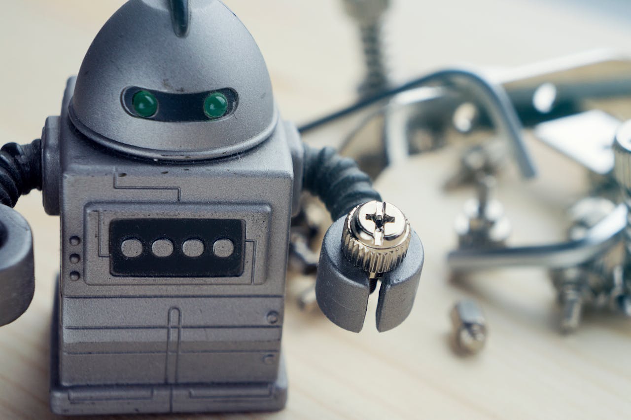 home-img Detailed view of a toy robot holding a metallic screw, surrounded by tools.